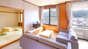 Zona salotto con divano accanto alla stanza tatami e vista dalla finestra