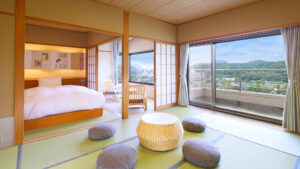 Camera in tatami con letto, cuscini da pavimento e grande finestra