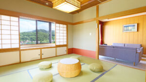 Camera in tatami con tavolo basso, cuscini da pavimento e divano