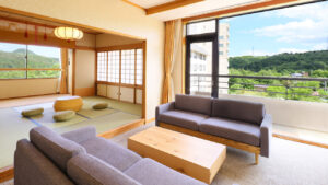 Camera in tatami con area salotto con divano e vista dal balcone