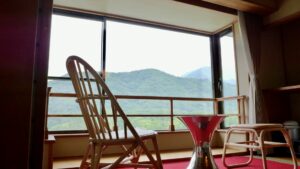 山の景色を望む窓辺の椅子と小さなテーブル