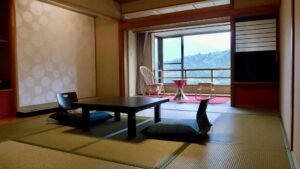窓際に低いテーブルと椅子がある和室