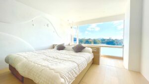 Letto accanto a una grande finestra con vista sull’acqua