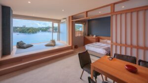 Camera da letto con ampia seduta accanto alla finestra affacciata sull’acqua