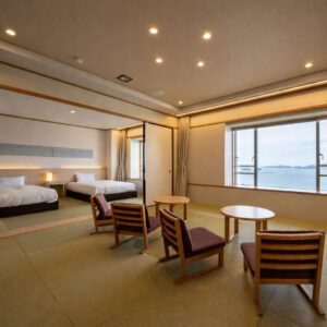 Camera in tatami con sedie, tavoli e letti singoli