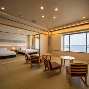 Camera in tatami con letti, sedie, tavoli e vista sull’oceano