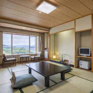 Camera in tatami con tavolino basso e sedie accanto alla finestra