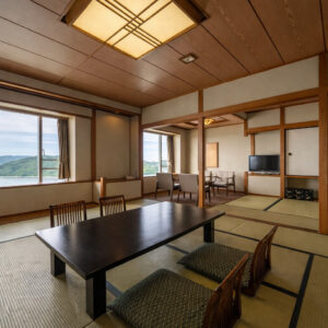 Camera in tatami con tavolo basso, cuscini da pavimento e sedie