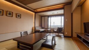 配有矮桌、椅子和窗边座位的榻榻米客房