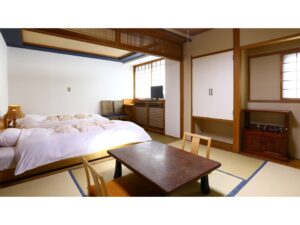 低いベッドとテーブルのある畳の客室