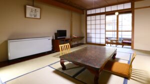 窓辺に低いテーブルと椅子がある畳の部屋