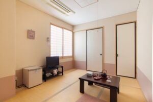 配有矮桌、椅子和电视的榻榻米客房
