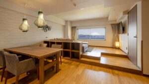 ダイニングテーブル、ソファ、窓からの眺めがある客室