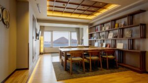 テーブル、椅子、本棚、窓のある図書館風の客室