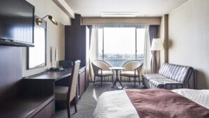 配有床、沙发、书桌和窗边座位的客房