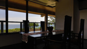 Table à manger et chaises près des grandes fenêtres de la chambre