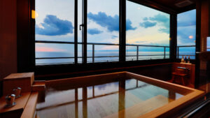 Bain en bois privé près de grandes fenêtres avec vue sur la mer