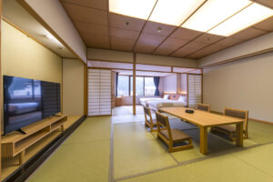 Chambre en tatami avec table basse, chaises et lits