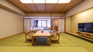 Chambre en tatami avec table basse, chaises et télévision