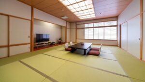 Chambre en tatami avec table basse, coussins de sol et télévision