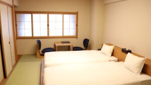 Lits jumeaux dans une chambre d'hôtes en tatami avec table