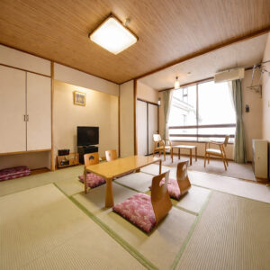 Tatamizimmer mit niedrigem Tisch, Bodensesseln und Fensterplätzen