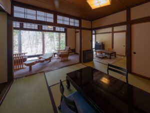 Chambre en tatami avec tables basses et chaises près des fenêtres
