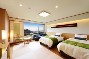 Twin beds in a guest room with sofa and view