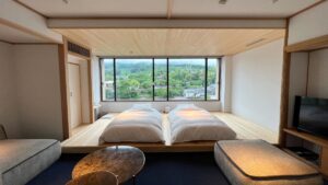 Twin beds by a large window in the room