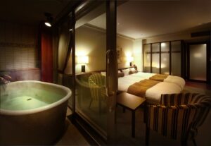 Bain rond privé à côté de la chambre, visible à travers des portes vitrées