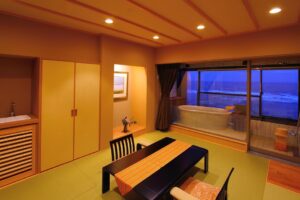 Chambre en tatami avec table basse et vue sur le bain du balcon