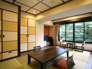 Habitación de tatami con mesa baja y sillas junto a la ventana