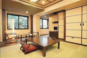 Habitación de tatami con mesa baja, sillas y ventana