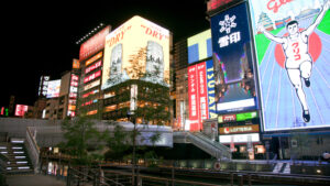 灯火通明的城市广告牌和运河步道夜景