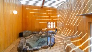 Bagno privato in pietra in una camera rivestita in legno