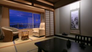 Camera con tatami, sedie, tavolo e portafinestra sul balcone