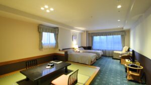 Letti singoli in una camera in tatami con area salotto