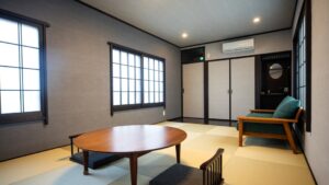 Tatami-Zimmer mit niedrigem Tisch und Stuhlsitzen