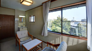 Sedie e tavolo accanto a una grande finestra nella camera