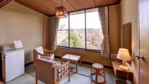 Camera in tatami con sedie, tavolo e vista dalla finestra