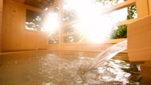 Open-air wooden bath with water flowing in