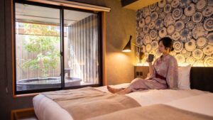 Woman sitting on beds beside private open-air bath