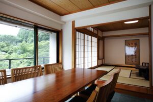 Habitación de tatami con mesa de comedor y sillas junto a la ventana