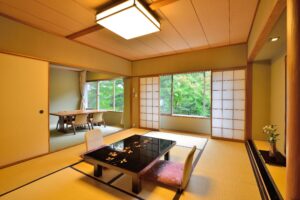 Habitación de tatami con mesa baja y sillas junto a la ventana