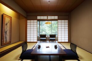 Habitación de tatami con mesa baja y sillas junto a la ventana