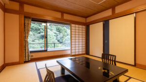 Habitación de tatami con mesa baja y sillas junto a la ventana