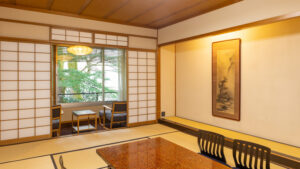 Habitación de tatami con mesa baja y sillas junto a la ventana