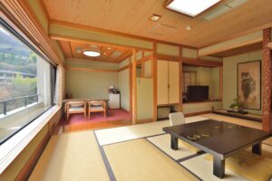 Habitación de tatami con mesa baja y zona de asientos junto a la ventana