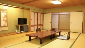 低いテーブルと座椅子のある畳の客室