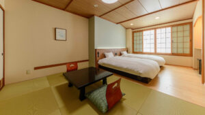 Lits à côté d’un coin salon en tatami dans une chambre de style japonais